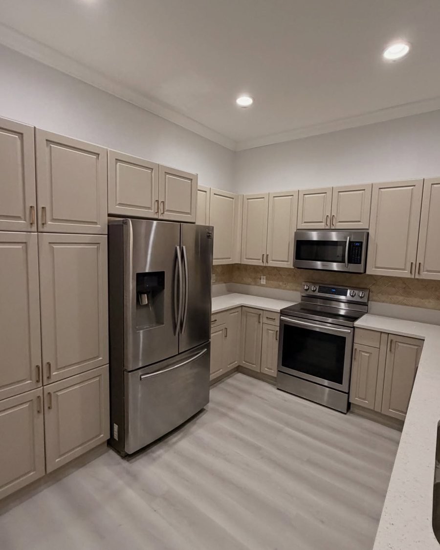 After: the same kitchen with the cabinets painted a warm cream with brass pulls
