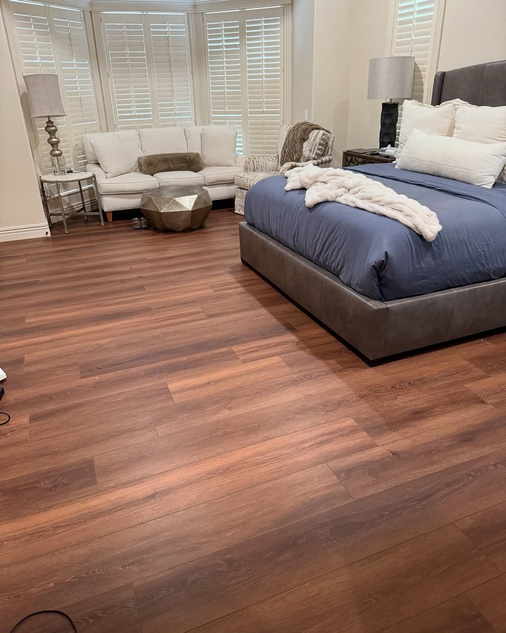 Bedroom with warm brown wood-look plank flooring