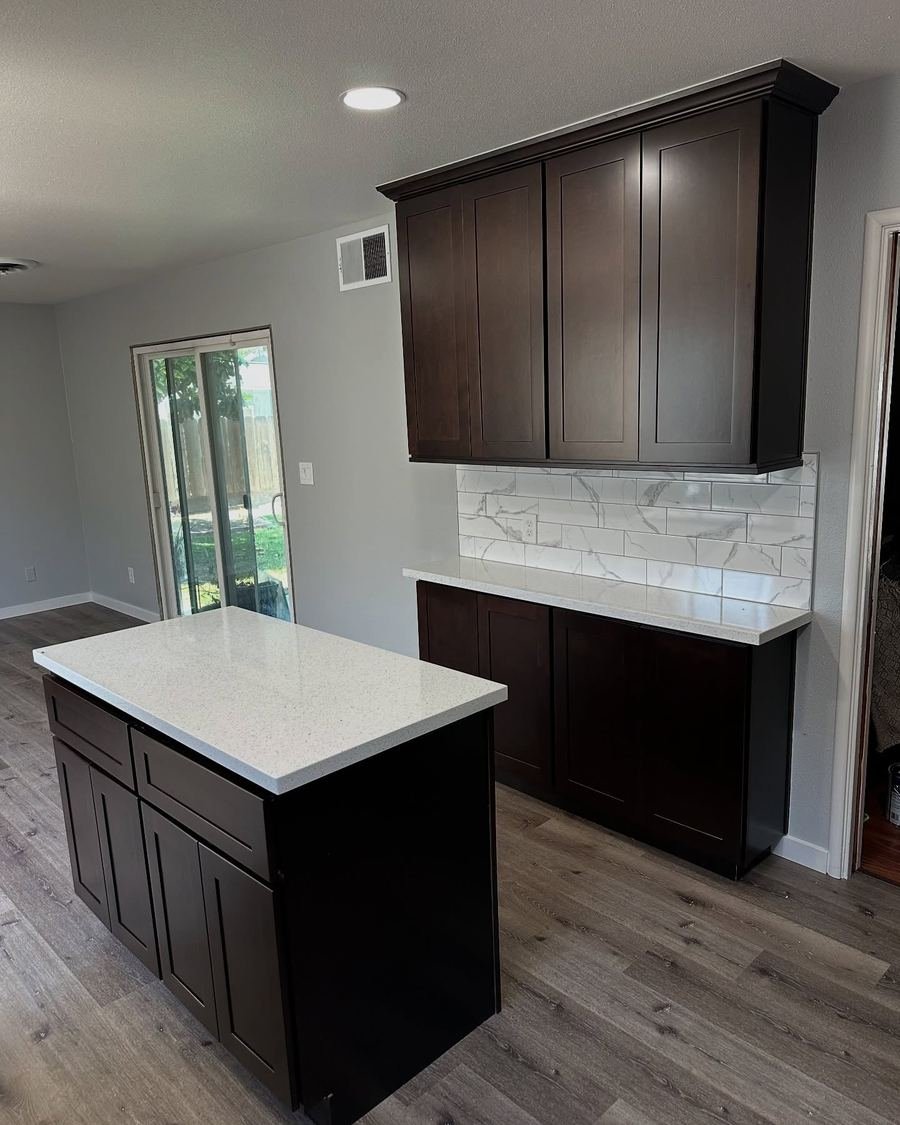 Kitchen with espresso cabinets, white countertops and a marble-look slab backsplash