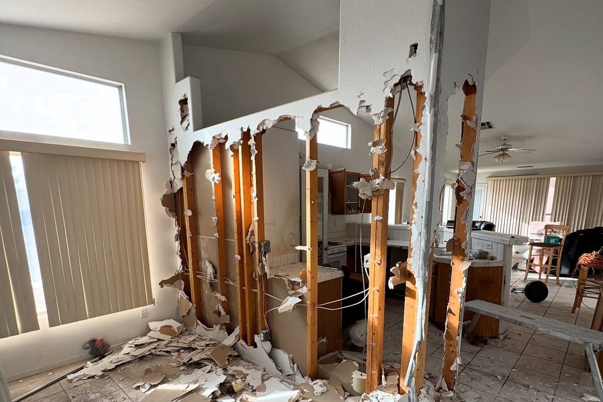 Kitchen remodel in progress with a wall being opened up to the living room