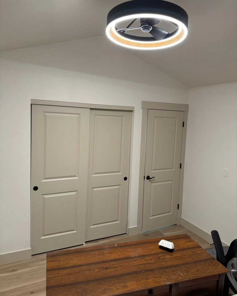 Bedroom with sliding closet doors and a hinged door painted greige